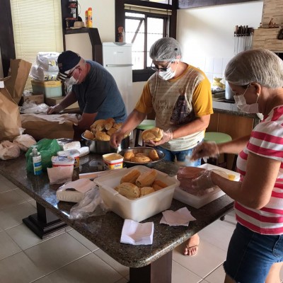 Voluntários da Igreja Católica fazem marmitas para servir aos moradores de rua, em Joinville